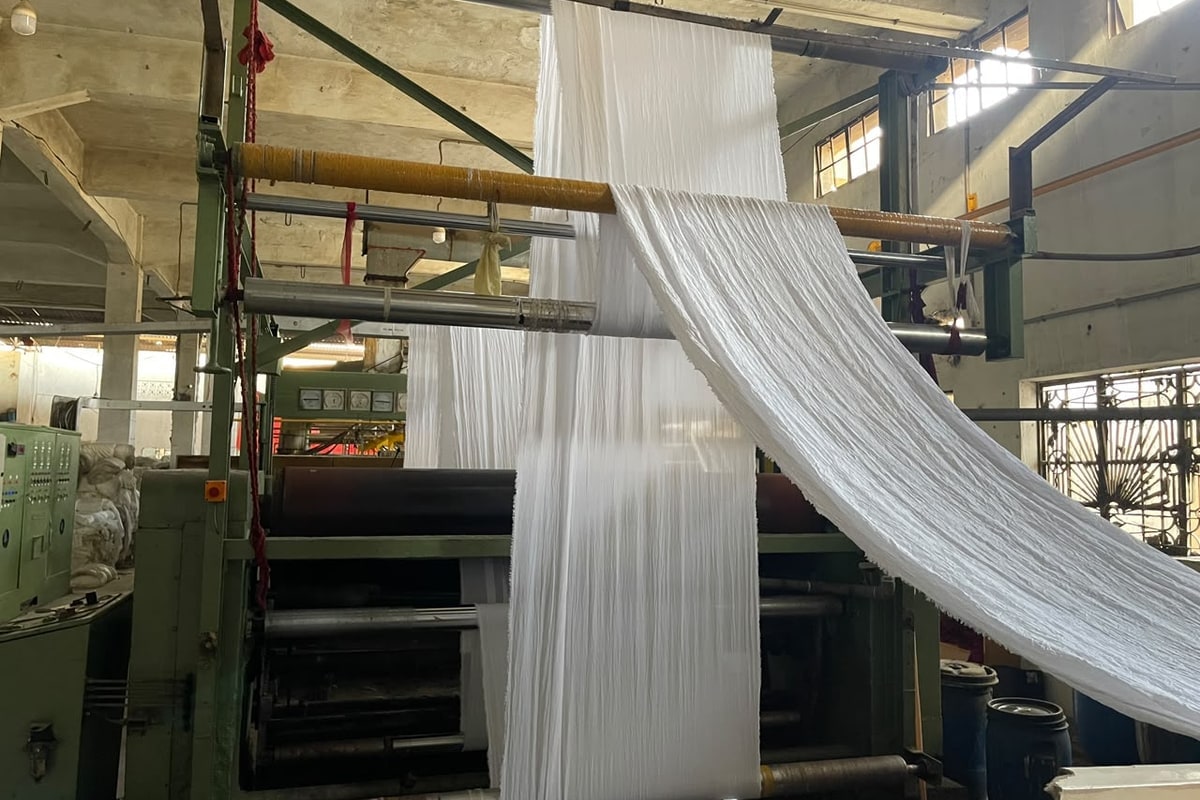 White fabric moving through the preparation line.